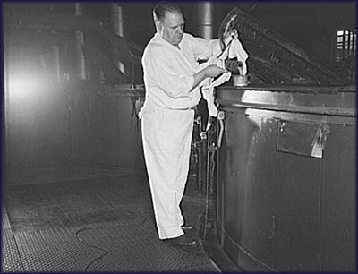 Worker at Proctor & Gamble's Cincinnati distribution taking a sample of soap from a vat. Photo by Howard R. Hollem, June 1943. 