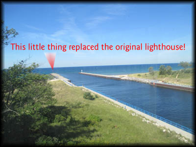 White River Light Station This photo, taken from the tower, shows the canal that connects Lake Michigan, seen here, and Lake White. The arrow in the photo points to the wee little beacon that replaced the beautiful White River Light Station.